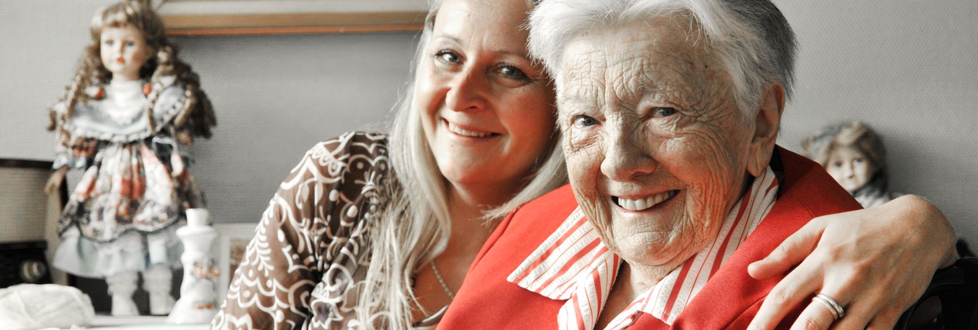 Seniorin mit lächelnder Betreuerin in Tagespflege