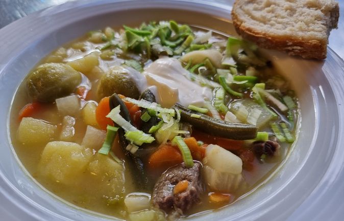 Gemüsesuppe mit Kartoffeln, Karotten, grünen Bohnen, Stück Fleisch und Brot